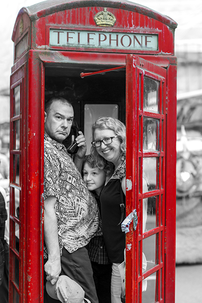Fun portrait of a family in a telephone box while visiting London