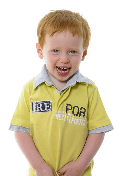 Studio portrait of a small boy with a mischievious grin